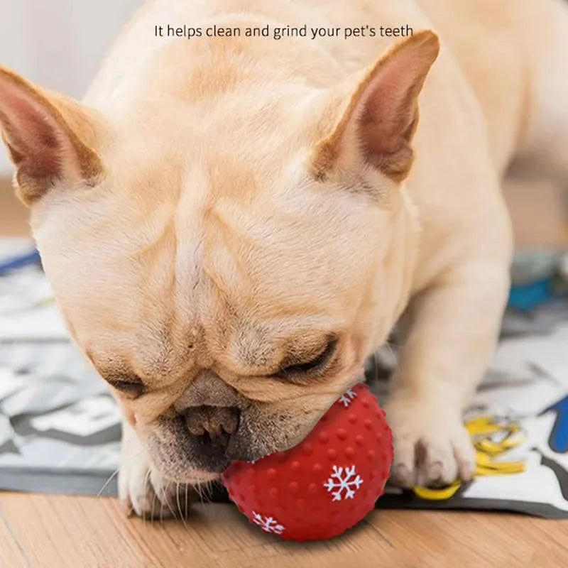 Red and green Christmas snowflake print dog chew ball with air vents, approx 7cm diameter.