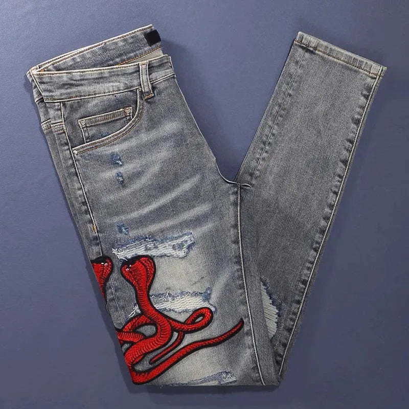 Men's slim fit cotton jeans with washed-out finish, hole patch detailing, and embroidery in old colour