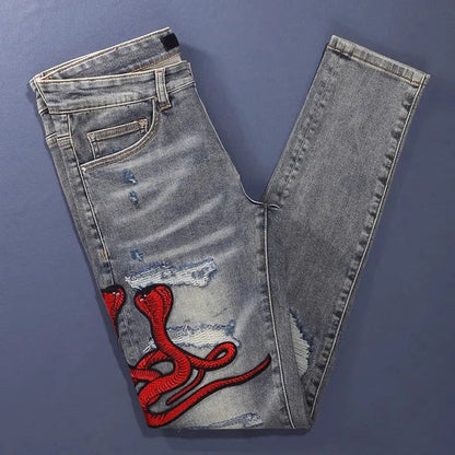 Men's slim fit cotton jeans with washed-out finish, hole patch detailing, and embroidery in old colour