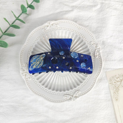 Oversized star barrettes in starry sky colours showing minimalist design and irregular elements
