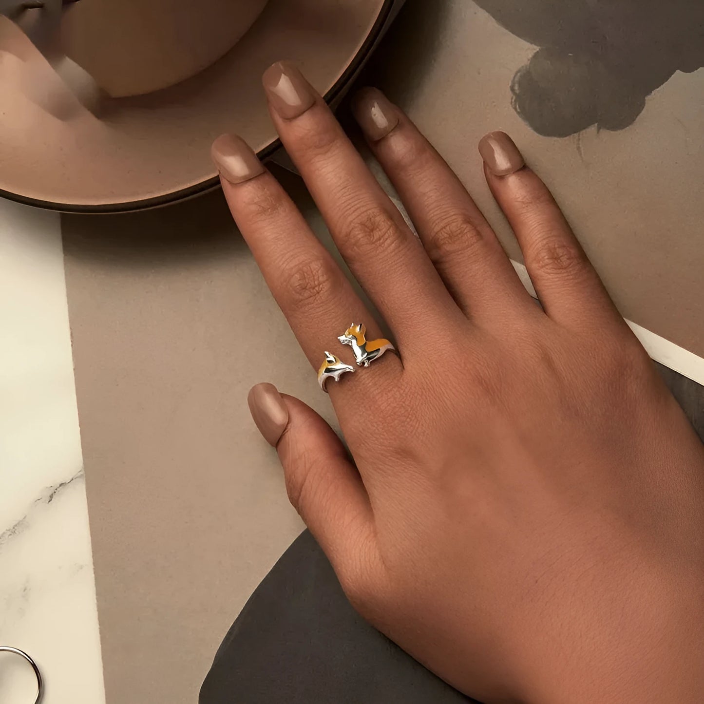 Close-up of an adjustable silver-toned ring with a detailed cartoon corgi dog design.