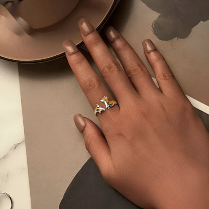 Close-up of an adjustable silver-toned ring with a detailed cartoon corgi dog design.