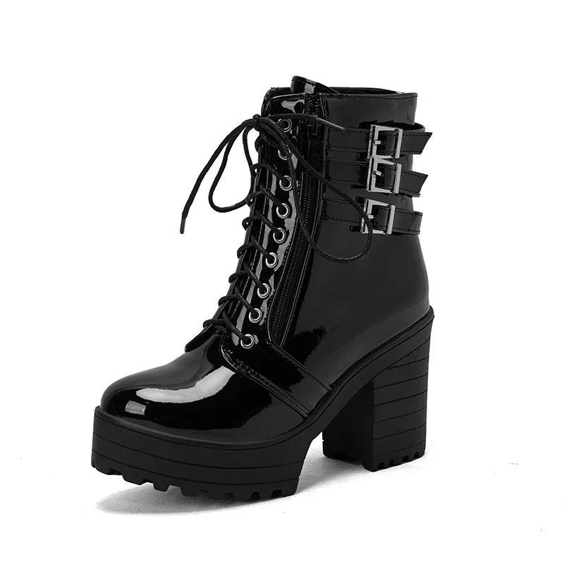 Women's black chunky heel ankle boots with round toe and front lace-up on a wooden floor.