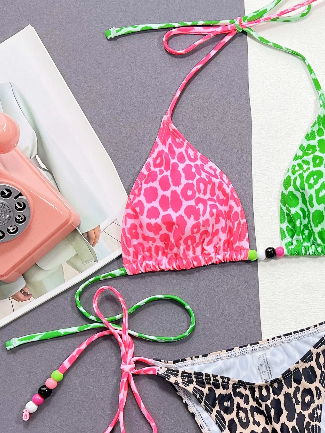 Women's leopard print two-piece bikini swimsuit with bra and briefs on a mannequin.