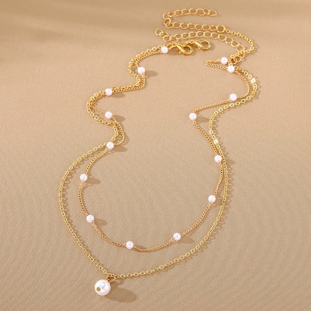 Elegant gold pearl tassel necklace with double-layered design and adjustable chain