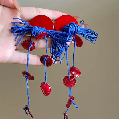 Handmade geometric women's earrings with blue resin flower and cloth material on silver needle setting.