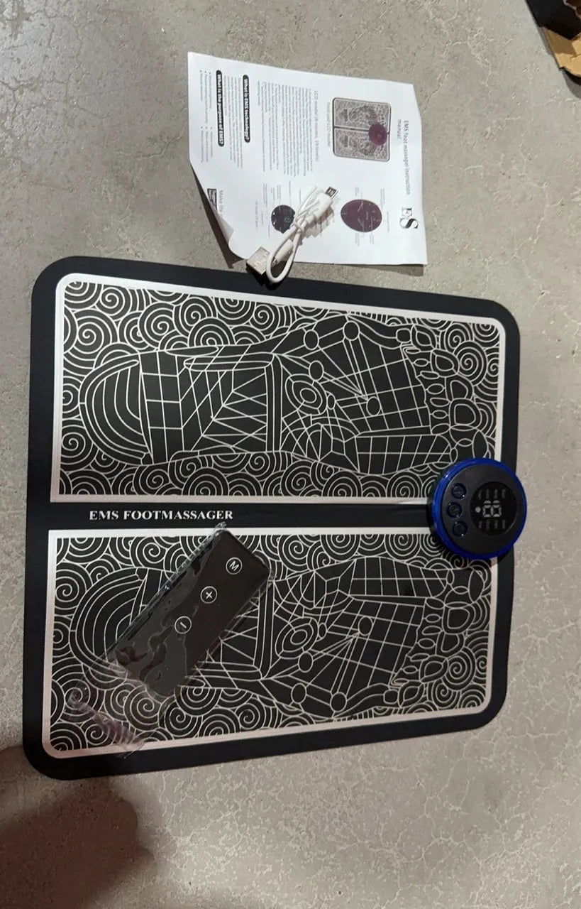 Leather foot massage cushion with LCD display and wireless remote control on a floor.