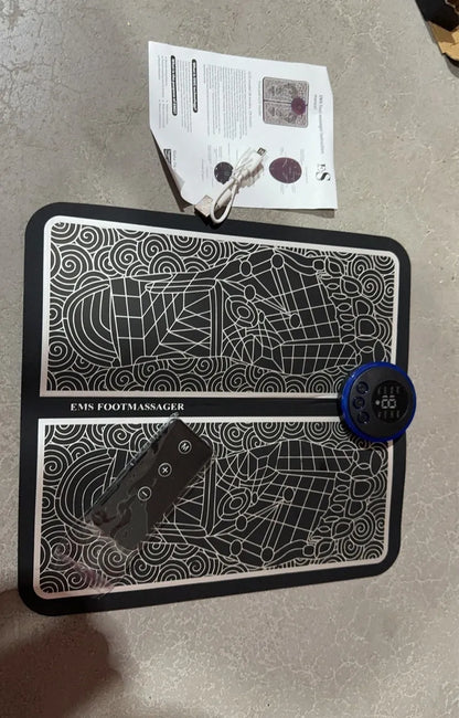 Leather foot massage cushion with LCD display and wireless remote control on a floor.