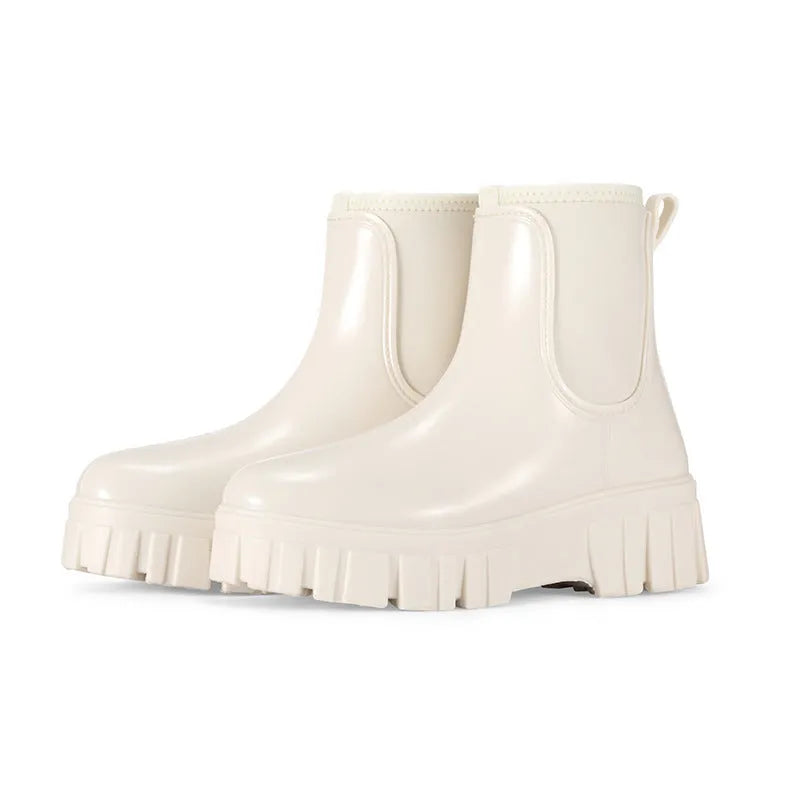 Women's creamy-white low tube PVC rain boots with a flat heel and thickening sole, shown from the side.