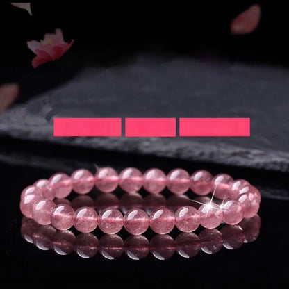 A women's bracelet made of polished strawberry quartz crystal beads in one of three size options.