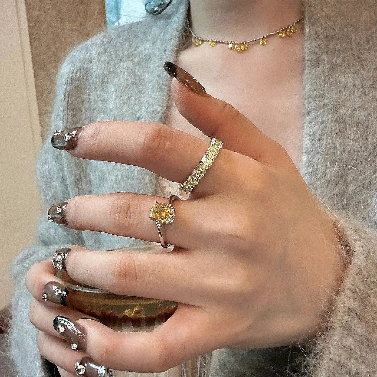 Women's yellow rock sugar crystal copper fashion ring on a hand.