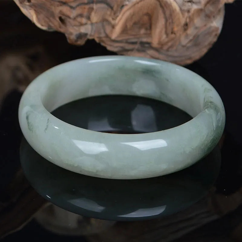 Natural Jinsi Jade Chinese bracelet in a closed bangle design on a plain background.