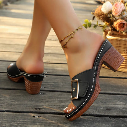 Women's black chunky heel slippers with a metal buckle and round toe, on a rubber sole
