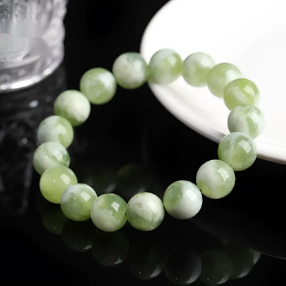 Green milk-in-water Xiuyan jade bracelet with polished geometric beads.