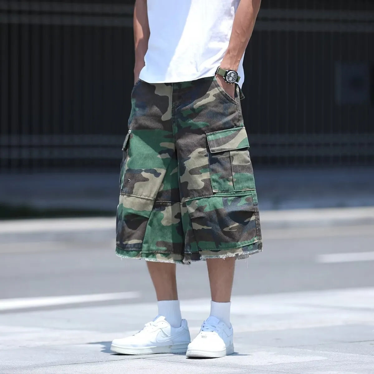 Man wearing loose-fit cropped camouflage shorts in a retro workwear style.