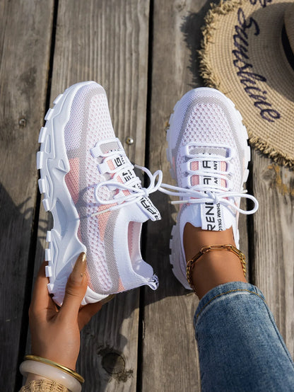 Women's Flyknit mesh lace-up sneaker in a grey colourway showing round toe and rubber sole.