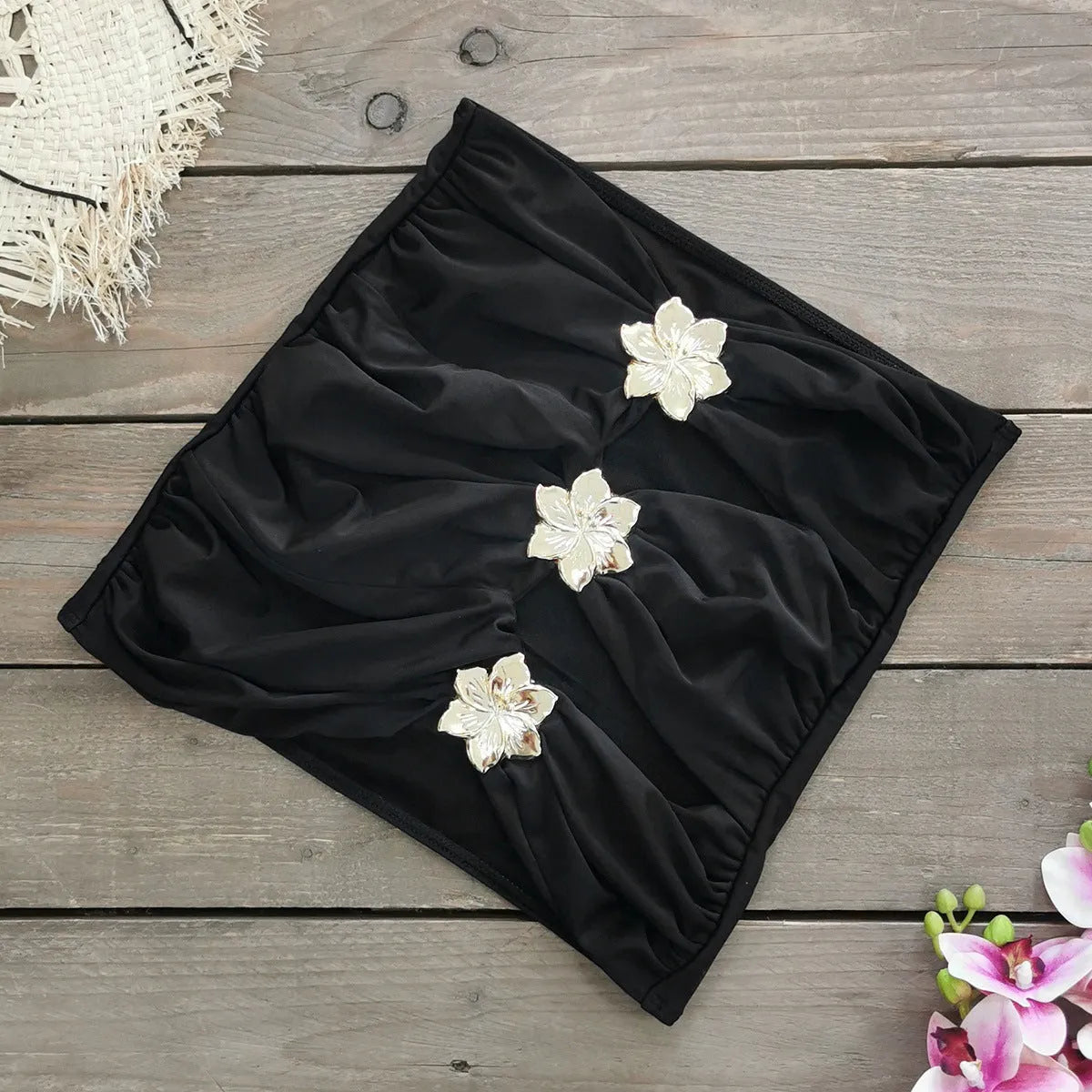 Solid colour women's one-piece swimsuit with attached short skirt and strapless hollow-out tube top design.