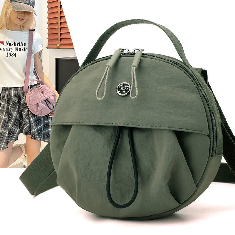 Out shoulder crossbody messenger bag in nylon showing interior zipped changing bag, phone pocket, and document compartment.