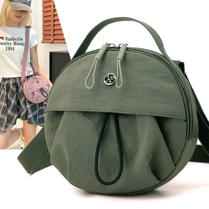 Out shoulder crossbody messenger bag in nylon showing interior zipped changing bag, phone pocket, and document compartment.