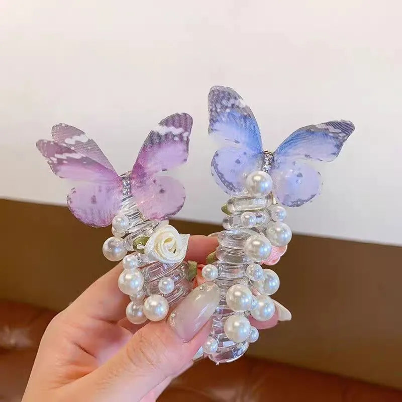Colourful butterfly and pearl elastic hair band for children on a white background.