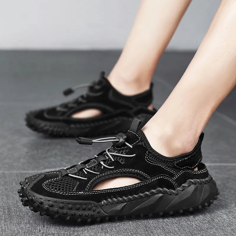 Men's black waterproof wading sandals with elastic band and perforated leather mesh upper on a rubber sole.