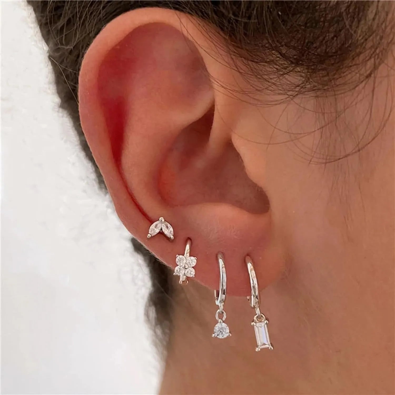 Set of four pairs of geometric copper earrings with zircon stones in gold or silver electroplated finish.