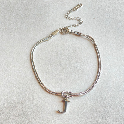 Elegant letter charm bracelets for women in gold and silver tones, featuring a delicate snake chain design and personalised letter charms.