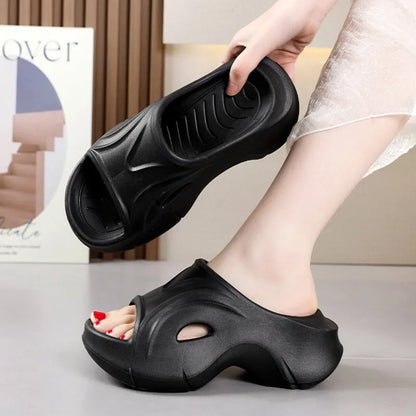 Women's white thick-soled EVA slippers with a round toe on a beach background.