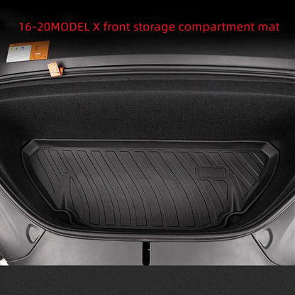 Custom black rubber floor mats fitted in a Tesla Model 3, showing deep grooves and raised edges.