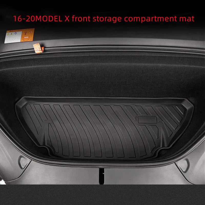 Custom black rubber floor mats with textured surface and TPE driver's footrest, fitted in a Tesla interior.