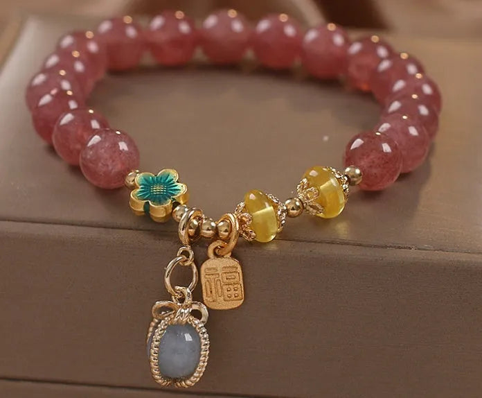 Red beaded bracelet with strawberry quartz gems, alloy clasp, and rhinestone details.
