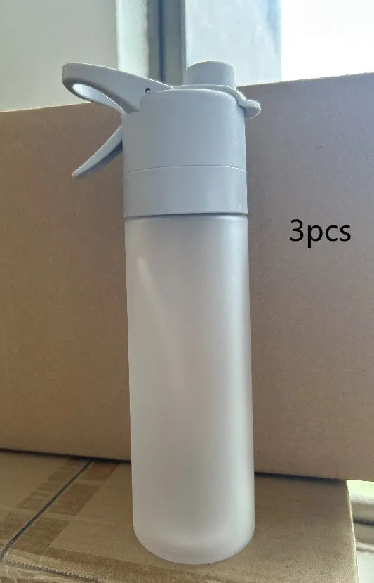 White spray water bottle with black leakproof lid and handle strap on a table