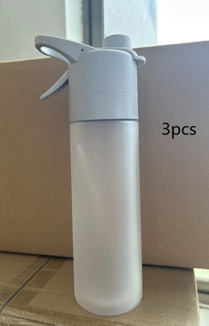White spray water bottle with black leakproof lid and handle strap on a table