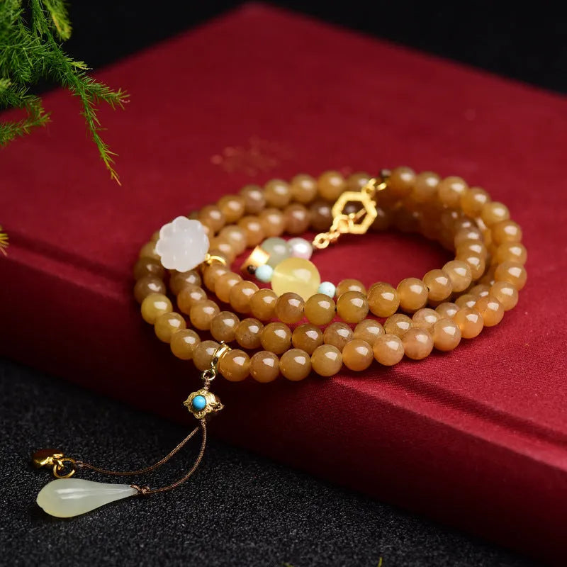 Women's green pine bead bracelet with jade leaves and sequin details on wrist