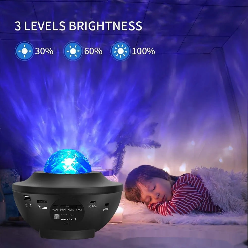 Small black bowl-shaped starry sky projection lamp with remote control on a desk.
