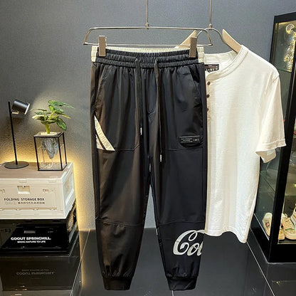 Black men's cropped casual trousers with ankle band made from thin ice silk cotton fabric.