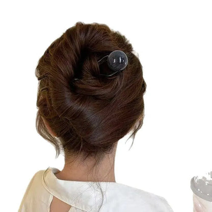 A set of U-shaped acrylic hair barrettes with a simple ball decoration in beige, caramel, and dark grey colours.