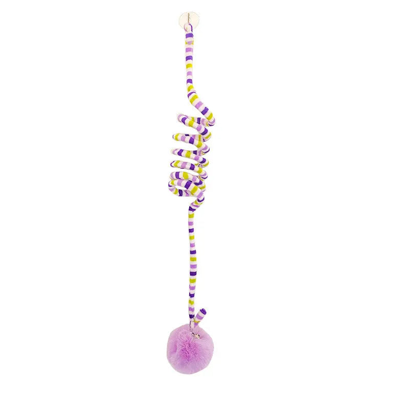 Hanging cat toy with spring, bell, and inflatable ball attached to a door via a suction cup.