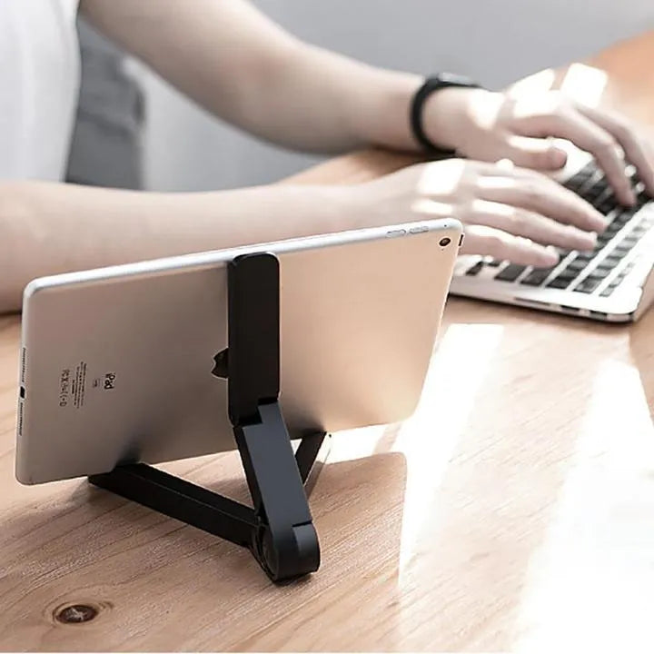 Black foldable tablet holder open in landscape mode holding a tablet, showing side buttons and non-slip base.