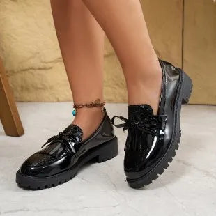 Women's brown artificial PU loafers with a bow detail on the pointed toe, shown on a size label.