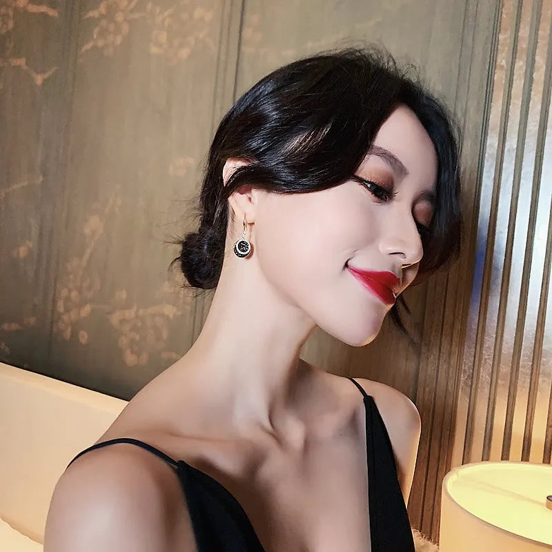 Matte black geometric circle alloy earrings with retro Hong Kong style, shown from the front.