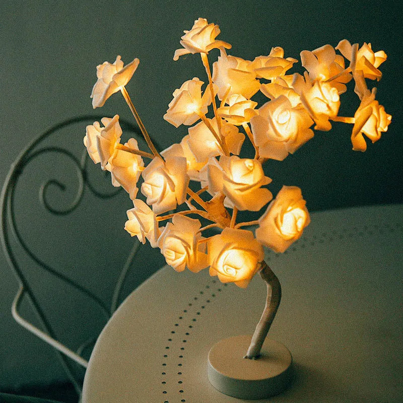 White and red rose flower LED lamp on a table with bonsai tree shape and warm white glow.