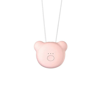 Small pink wearable air purifier pendant on a necklace, showing USB charging port and single button.