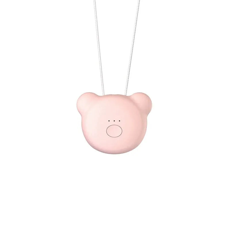 Compact pink USB air purifier necklace on a table with charging cable, showing dimensions 1.5 by 5.7 cm.
