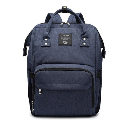 Stylish maternity diaper bag in various colors, featuring a paper bag design, separate bottle compartment, and discreet breastfeeding button.