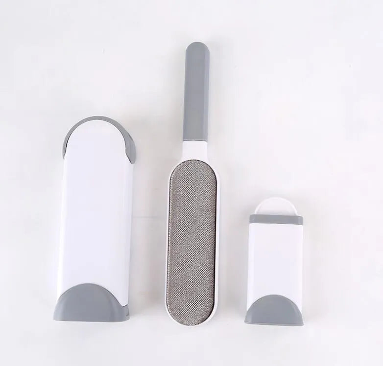 Blue reusable pet hair removal brush with double-sided head next to its self-cleaning base.