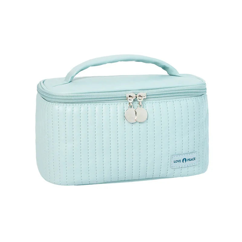 Open-top pastel pink PU leather makeup bag with a flat base, showing interior space.
