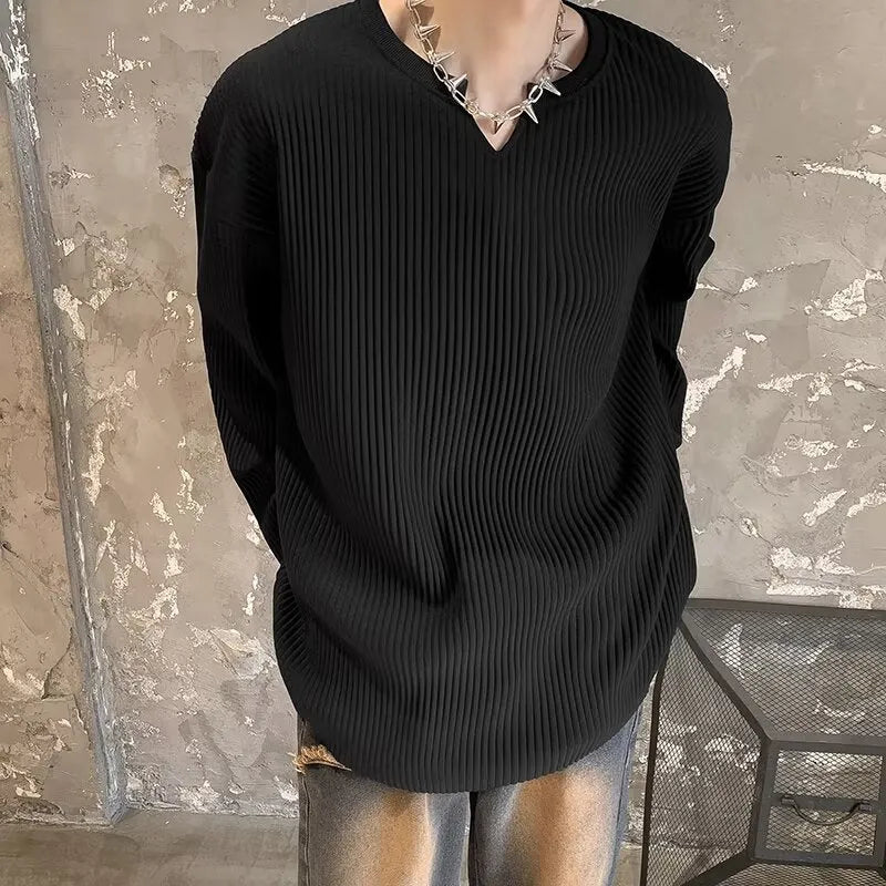 A woman wearing a black and white striped, loose-fit, long-sleeve pullover jumper.