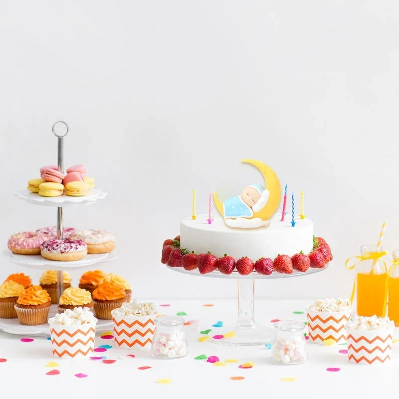 Adorable moon-themed cake decorations and party supplies for baby birthday celebrations