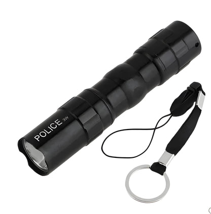 Black aluminium mini LED flashlight shown next to a AA battery for scale.